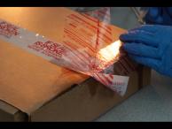 One of the teams carefully removes the security tape from the outside of the tamper contest package.